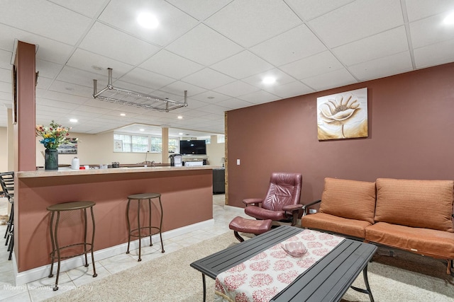 living room with light tile patterned flooring, a paneled ceiling, and recessed lighting