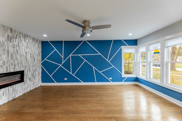 unfurnished living room featuring a fireplace, hardwood / wood-style floors, and ceiling fan