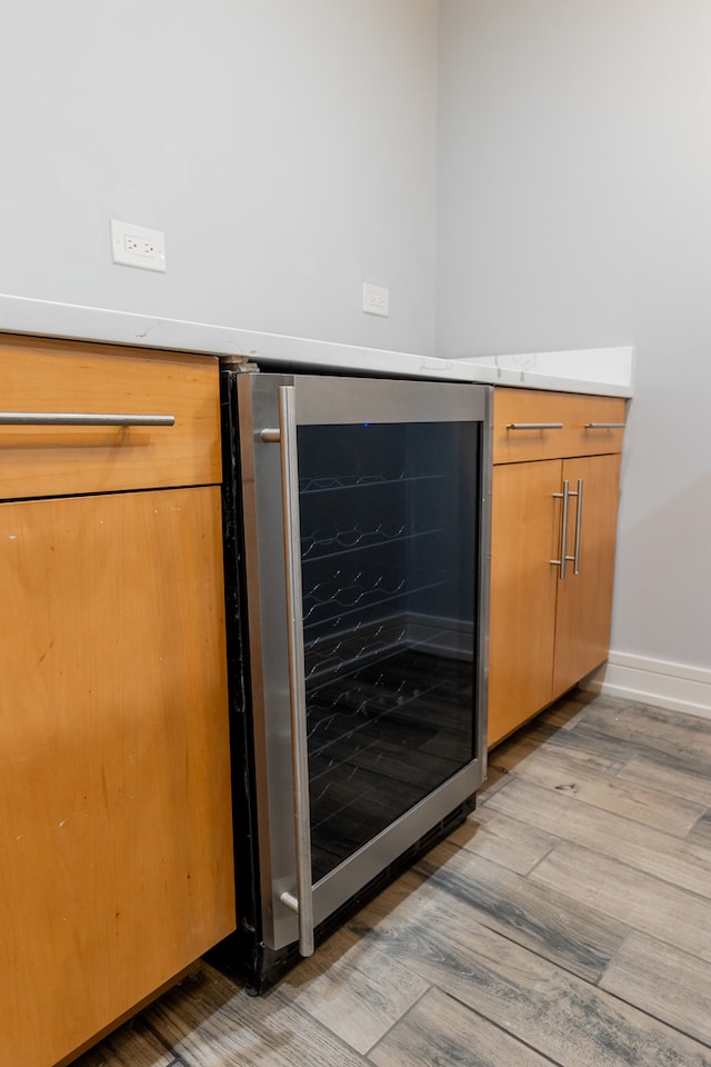 details featuring wine cooler and light hardwood / wood-style flooring