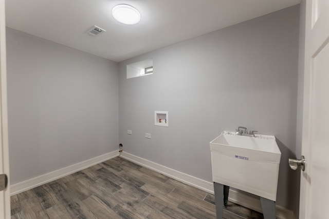 washroom with dark hardwood / wood-style flooring, washer hookup, and sink