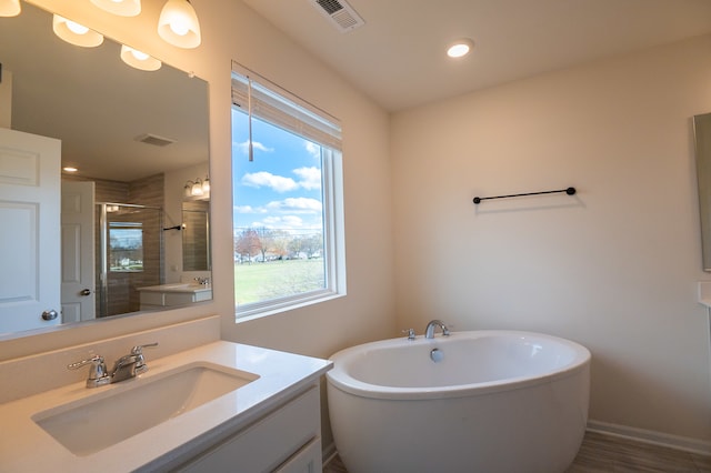 bathroom with vanity, independent shower and bath, and hardwood / wood-style flooring