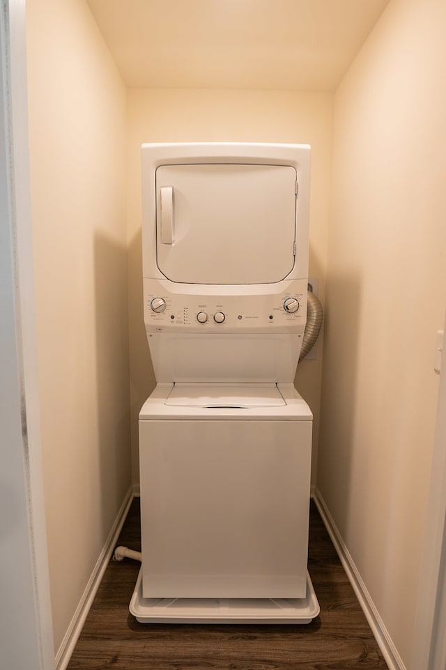 washroom featuring dark hardwood / wood-style flooring and stacked washer and clothes dryer