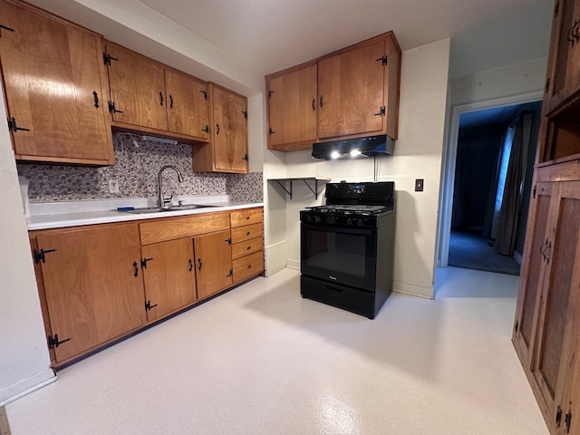 kitchen featuring black gas range, tasteful backsplash, and sink