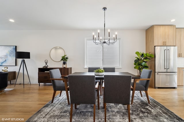 dining space with wood-type flooring and a notable chandelier