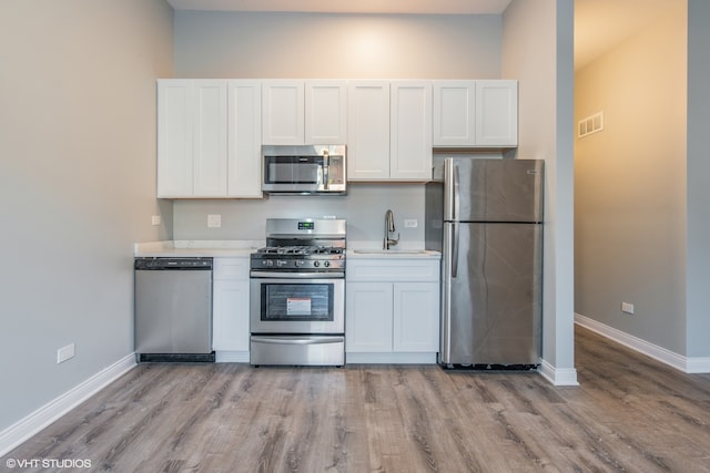 kitchen featuring light hardwood / wood-style flooring, stainless steel appliances, white cabinetry, and sink