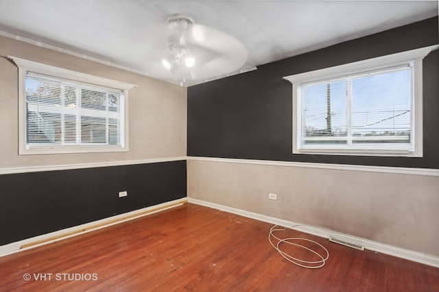 empty room with hardwood / wood-style floors and ceiling fan