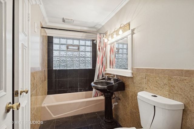 bathroom with toilet, shower / tub combo with curtain, tile walls, and ornamental molding