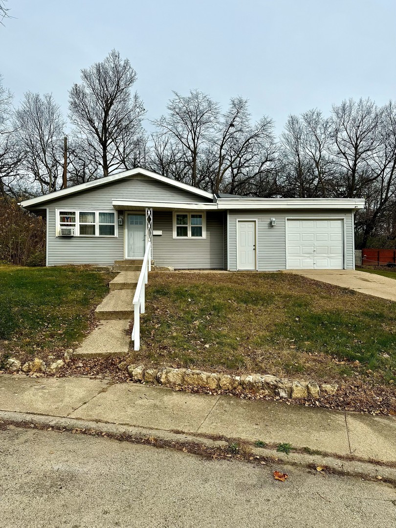 ranch-style house with a front yard and a garage