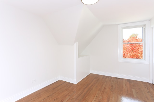 additional living space featuring hardwood / wood-style flooring and lofted ceiling