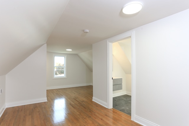 bonus room with hardwood / wood-style floors and vaulted ceiling