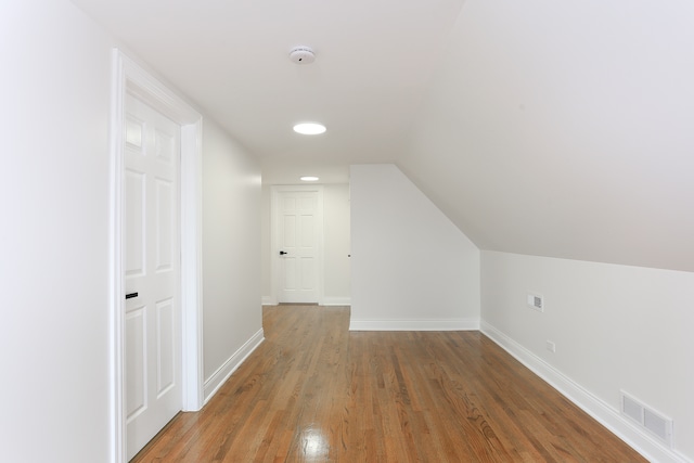 additional living space featuring lofted ceiling and dark hardwood / wood-style floors