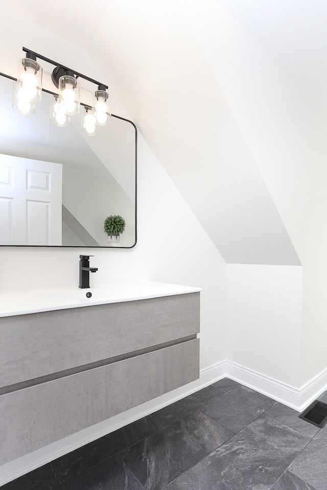 bathroom featuring vanity and vaulted ceiling