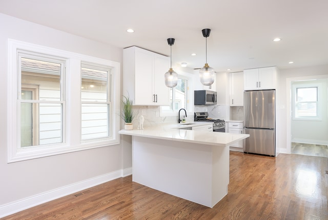 kitchen featuring white cabinetry, a healthy amount of sunlight, tasteful backsplash, and stainless steel appliances