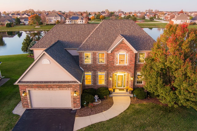 view of front of house featuring a water view, a front yard, and a garage