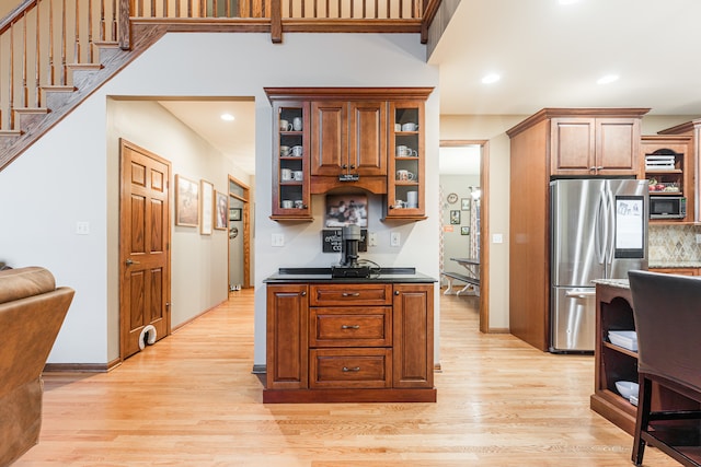 kitchen featuring decorative backsplash, light wood-type flooring, and stainless steel appliances