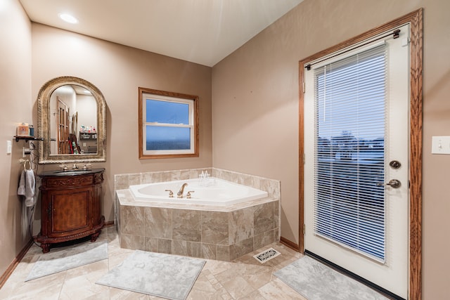 bathroom featuring vanity and a relaxing tiled tub