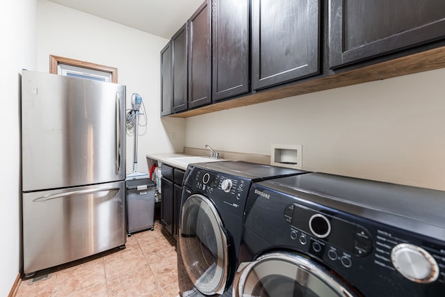 laundry room with light tile patterned flooring, washing machine and dryer, and sink