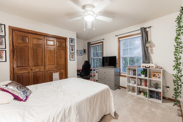 bedroom featuring ceiling fan, light carpet, and a closet