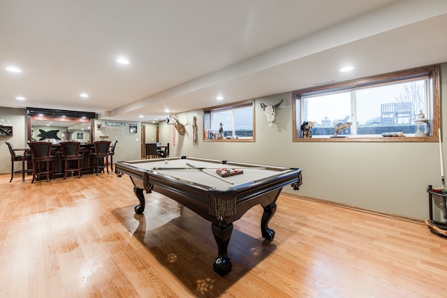 playroom featuring light hardwood / wood-style floors, pool table, and bar area