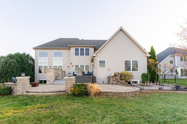 back of property with a yard and a patio