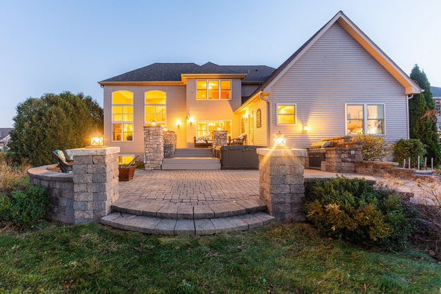 back house at dusk featuring a patio and an outdoor fire pit