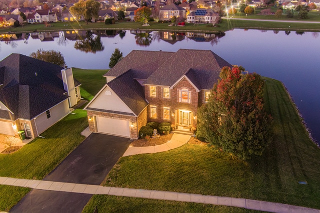 view of front of home featuring a garage, a water view, and a front yard