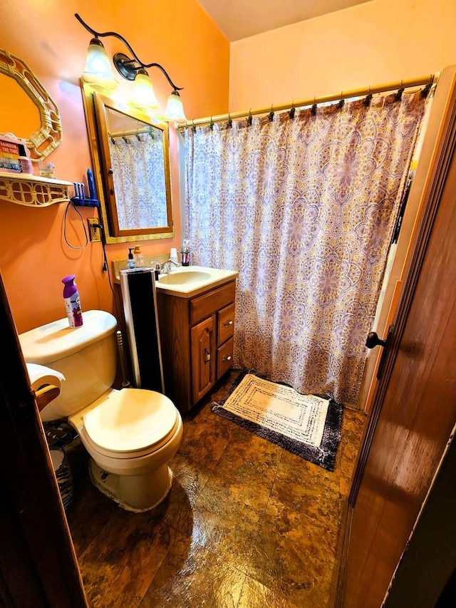 bathroom with curtained shower, vanity, and toilet