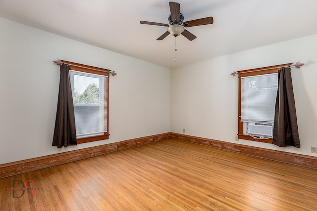 empty room with ceiling fan, cooling unit, and light wood-type flooring