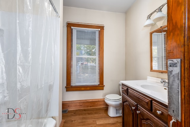 bathroom with walk in shower, hardwood / wood-style floors, vanity, and toilet