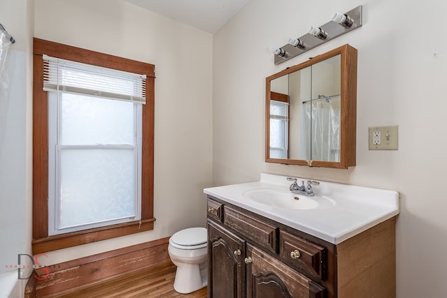 bathroom with a shower with shower curtain, vanity, hardwood / wood-style flooring, and toilet