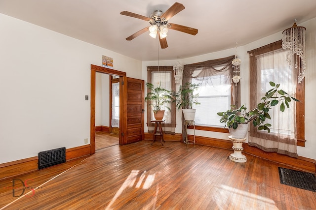 unfurnished room with hardwood / wood-style flooring, ceiling fan, and a healthy amount of sunlight