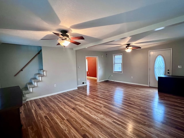 unfurnished living room with ceiling fan, dark wood-type flooring, and a textured ceiling