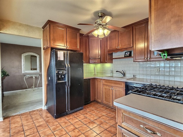 kitchen featuring ceiling fan, sink, black fridge, decorative backsplash, and light tile patterned floors