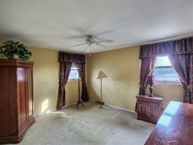 interior space with ceiling fan, light carpet, and multiple windows