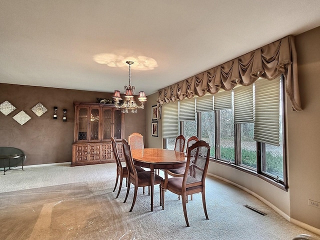 dining room with carpet and a notable chandelier