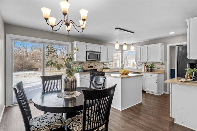 dining area with dark wood-type flooring and an inviting chandelier