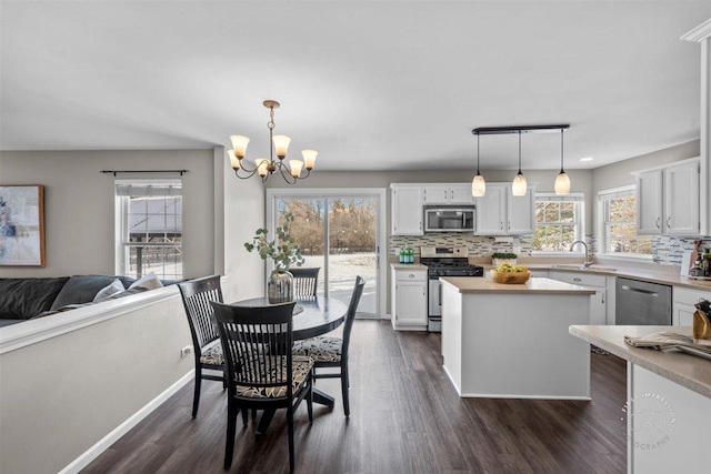 dining area featuring plenty of natural light, dark hardwood / wood-style flooring, and a chandelier