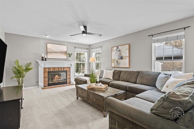 living room with ceiling fan, light colored carpet, and a fireplace