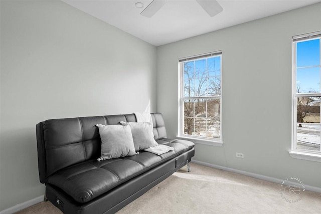 living area featuring light colored carpet and ceiling fan