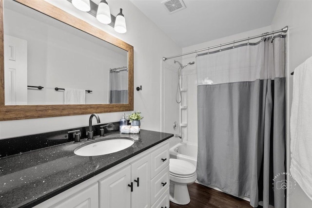 full bathroom featuring hardwood / wood-style flooring, shower / bathtub combination with curtain, vanity, and toilet