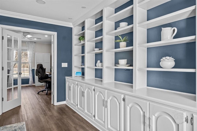 corridor featuring french doors, crown molding, and dark wood-type flooring