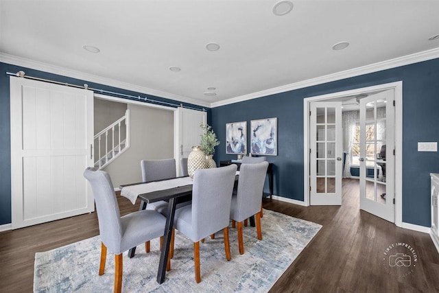 dining room featuring french doors, dark hardwood / wood-style floors, a barn door, and crown molding