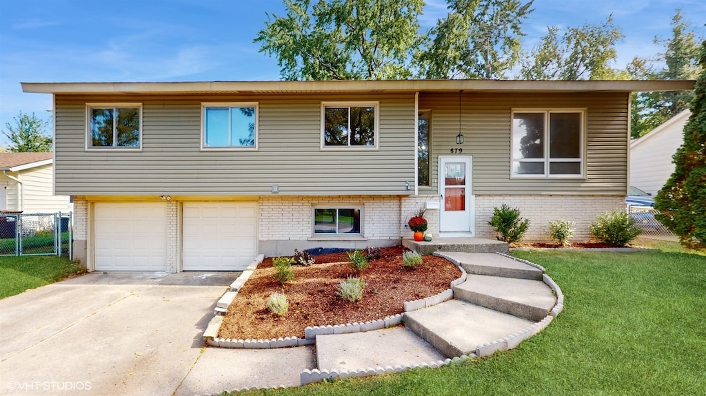 split foyer home featuring a garage and a front yard