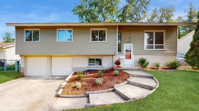 split foyer home featuring a garage and a front yard