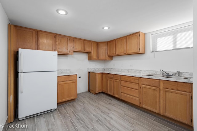 kitchen featuring white refrigerator, sink, and light hardwood / wood-style flooring