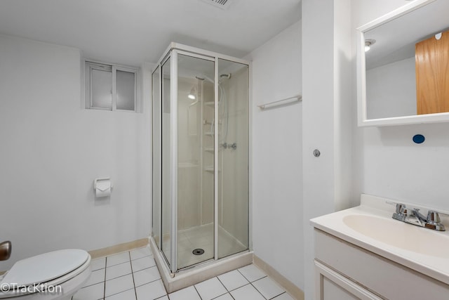 bathroom with tile patterned floors, vanity, toilet, and a shower with shower door