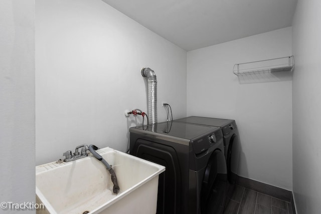 washroom with washer and dryer, dark hardwood / wood-style flooring, and sink