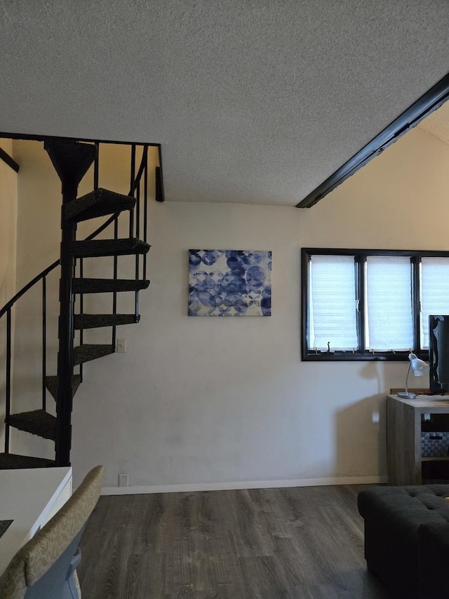 stairway with a textured ceiling and hardwood / wood-style flooring