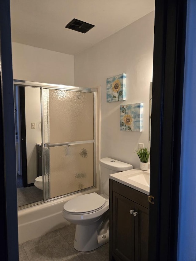 full bathroom featuring tile patterned floors, vanity, enclosed tub / shower combo, and toilet