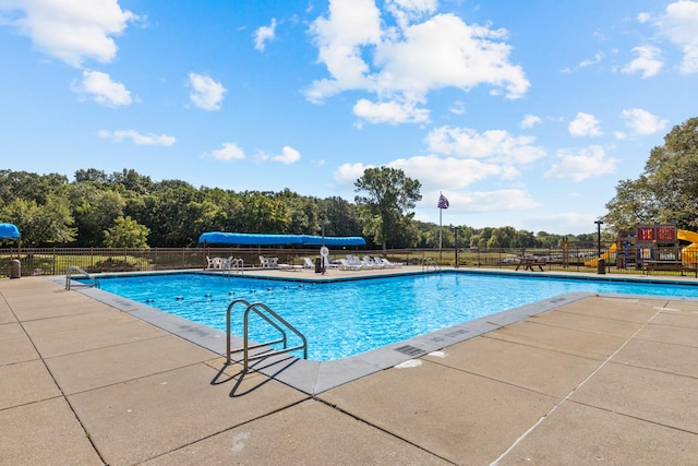 view of swimming pool featuring a patio area and a playground